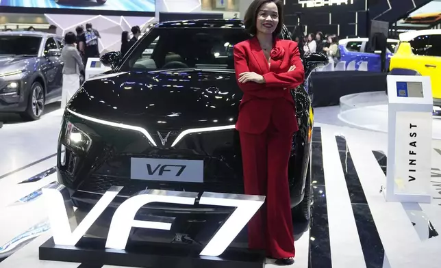 Vu Dang Yen Hang, chief executive officer of VinFast Thailand, poses in front of its electric vehicle VF7 during the 45th Bangkok Motor Show in Nonthaburi, Thailand, Tuesday, March 26, 2024. (AP Photo/Sakchai Lalit)