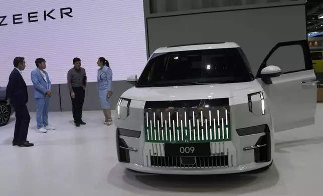 Visitors look at ZEEKR's electric vehicles "009" during the 45th Bangkok Motor Show in Nonthaburi, Thailand, Tuesday, March 26, 2024. (AP Photo/Sakchai Lalit)