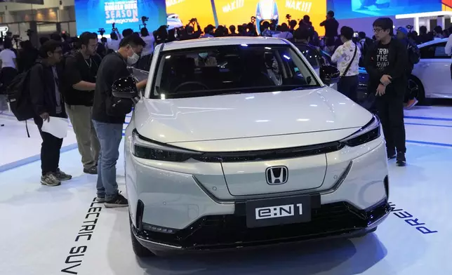 Visitors look at Honda's electric vehicle "E:N1" during the 45th Bangkok Motor Show in Nonthaburi, Tuesday, March 26, 2024. Thailand. (AP Photo/Sakchai Lalit)