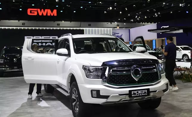 Visitors look at Great Wall Motor's electric vehicle "Poer Sahar" pickup truck during the 45th Bangkok Motor Show in Nonthaburi, Thailand, Tuesday, March 26, 2024. (AP Photo/Sakchai Lalit)