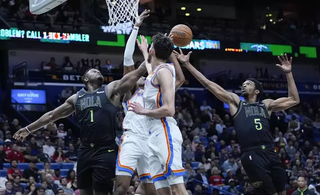 New Orleans Pelicans forward Zion Williamson (1) and forward Herbert Jones (5) battle for a rebound in the first half of an NBA basketball game against the Oklahoma City Thunder in New Orleans, Tuesday, March 26, 2024. (AP Photo/Gerald Herbert)