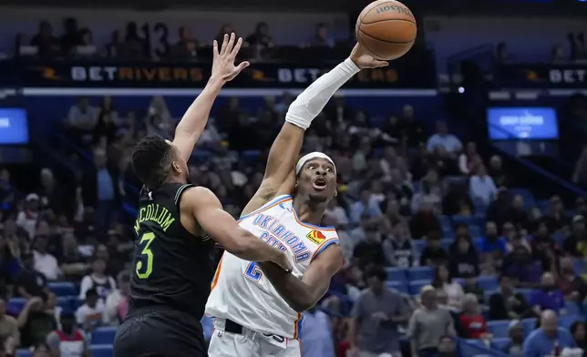 Oklahoma City Thunder guard Shai Gilgeous-Alexander battles under the basket with New Orleans Pelicans guard CJ McCollum (3) in the second half of an NBA basketball game in New Orleans, Tuesday, March 26, 2024. The Thunder won 119-112. (AP Photo/Gerald Herbert)