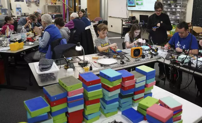 Workshop participants assemble LightSound devices at the New England Sci-Tech education center in Natick, Mass., on March 2, 2024. The creators of the device are working with other institutions with the goal of distributing at least 750 devices to locations hosting eclipse events in Mexico, the U.S., and Canada. (AP Photo/Mary Conlon)