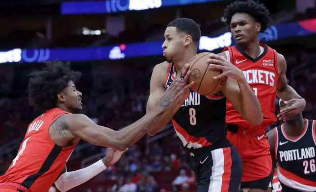 Portland Trail Blazers forward Kris Murray (8) pulls down a rebound between Houston Rockets guard Jalen Green, left, and forward Amen Thompson, right, during the first half of an NBA basketball game, Monday, March 25, 2024, in Houston. (AP Photo/Michael Wyke)