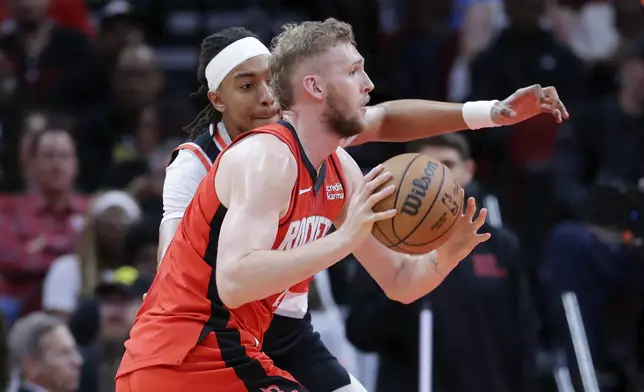 Houston Rockets center Jock Landale, right, passes the ball in front of Portland Trail Blazers center Moses Brown during the first half of an NBA basketball game, Monday, March 25, 2024, in Houston. (AP Photo/Michael Wyke)
