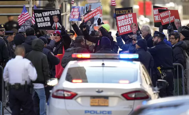 Protestors demonstrate outside Manhattan criminal court while awaiting the arrival of former President Donald Trump, Monday, March 25, 2024, in New York. A judge will weigh on Monday when the former president will go on trial. (AP Photo/Seth Wenig)