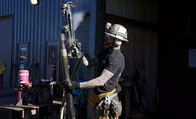 A woker checks on a piece of mining equipment at the Energy Fuels Inc. uranium Pinyon Plain Mine Wednesday, Jan. 31, 2024, near Tusayan, Ariz. The largest uranium producer in the United States is ramping up work just south of Grand Canyon National Park on a long-contested project that largely has sat dormant since the 1980s. (AP Photo/Ross D. Franklin)