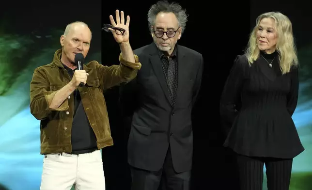 Michael Keaton, left, a cast member in the upcoming film "Beetlejuice Beetlejuice," discusses the film as director Tim Burton, center, and cast member Catherine O'Hara look on during the Warner Bros. Pictures presentation at CinemaCon 2024, Tuesday, April 9, 2024, in Las Vegas. (AP Photo/Chris Pizzello)