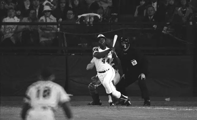 FILE - Atlanta Braves' Hank Aaron eyes the flight of the ball after hitting his 715th career homer in a game against the Los Angeles Dodgers in Atlanta, Ga., Monday night, April 8, 1974. Aaron broke Babe Ruth's record of 714 career home runs. Dodgers southpaw pitcher Al Downing, catcher Joe Ferguson and umpire David Davidson look on. Just in time for the 50-year anniversary of Hank Aaron's record 715th home run, Charlie Russo is making available video he shot of the homer. (AP Photo/Harry Harris, File)