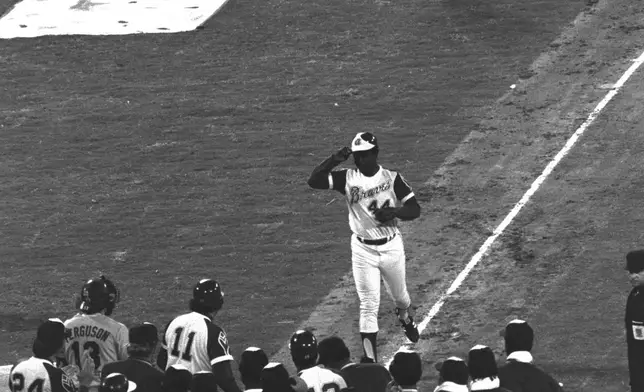FILE - Atlanta Braves' Hank Aaron tips his hat to teammates greeting him at home plate after hitting his 715th career home run during a baseball game against the Los Angeles Dodgers in Atlanta, Monday, April 8, 1974. Just in time for the 50-year anniversary of Hank Aaron's record 715th home run, Charlie Russo is making available video he shot of the homer. (AP Photo/Joe Sebo, File)