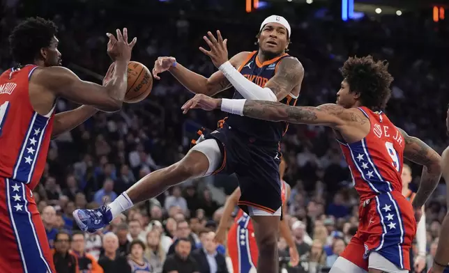 Philadelphia 76ers' Kelly Oubre Jr., right, knocks the ball away from New York Knicks' Miles McBride, center, as 76ers' Joel Embiid, left, defends during the second half of Game 2 in an NBA basketball first-round playoff series Monday, April 22, 2024, in New York. (AP Photo/Frank Franklin II)