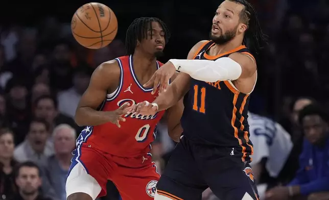 New York Knicks' Jalen Brunson (11) passes away from Philadelphia 76ers' Tyrese Maxey (0) during the first half of Game 2 in an NBA basketball first-round playoff series, Monday, April 22, 2024, in New York. (AP Photo/Frank Franklin II)