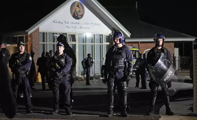 Security officers stand guard outside Orthodox Assyrian church in Sydney, Australia, Monday, April 15, 2024. Police in Australia say a man has been arrested after a bishop and churchgoers were stabbed in the church. There are no life-threatening injuries. (AP Photo/Mark Baker)
