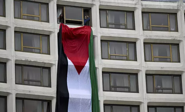 Demonstrators hang a Palestinian flag out a window at the Washington Hilton hotel during a protest over the Israel-Hamas war, at the White House Correspondents' Association Dinner, Saturday April 27, 2024, in Washington. (AP Photo/Terrance Williams)