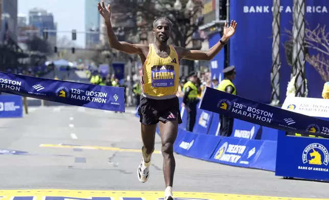 Sisay Lemma, of Ethiopia, breaks the tape to win the Boston Marathon, Monday, April 15, 2024, in Boston. (AP Photo/Steven Senne)