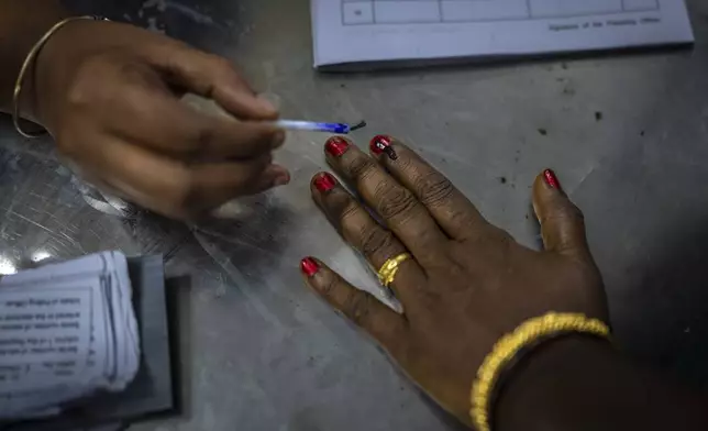 A polling official puts indelible ink mark on the index finger of a woman as she arrives to vote during the first round of voting of India’s national election in Chennai, southern Tamil Nadu state, Friday, April 19, 2024. Nearly 970 million voters will elect 543 members for the lower house of Parliament for five years, during staggered elections that will run until June 1. (AP Photo/Altaf Qadri)