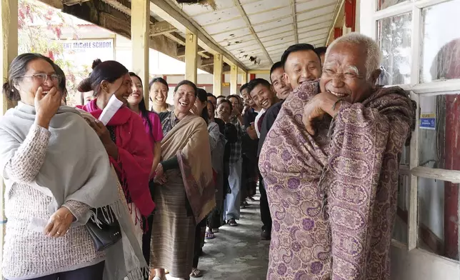 Angami Nagas laugh as an elderly man reacts to the camera at a polling station in Chedema village, in the northeastern Indian state of Nagaland, Friday, April 19, 2024. (AP Photo/Yirmiyan Arthur)
