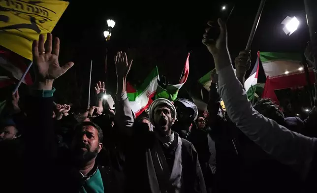 Iranian demonstrators chant slogans during an anti-Israeli gathering in front of the British Embassy in Tehran, Iran, early Sunday, April 14, 2024. Iran launched its first direct military attack against Israel on Saturday. (AP Photo/Vahid Salemi)