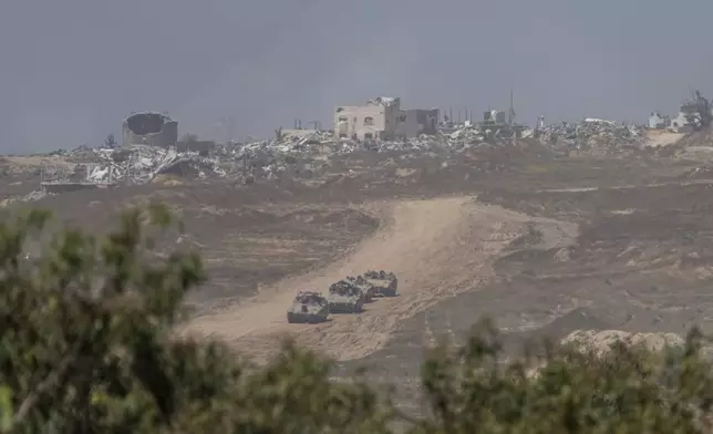 Israeli armored personnel carriers (APC's) move near the Israeli-Gaza border as seen from southern Israel, Wednesday, April 17, 2024. (AP Photo/Ohad Zwigenberg)