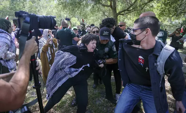 A pro-Palestinian protester is grabbed by University of South Florida police as they begin to clash on campus Monday, April 29, 2024, in Tampa, Fla. (Chris Urso/Tampa Bay Times via AP)