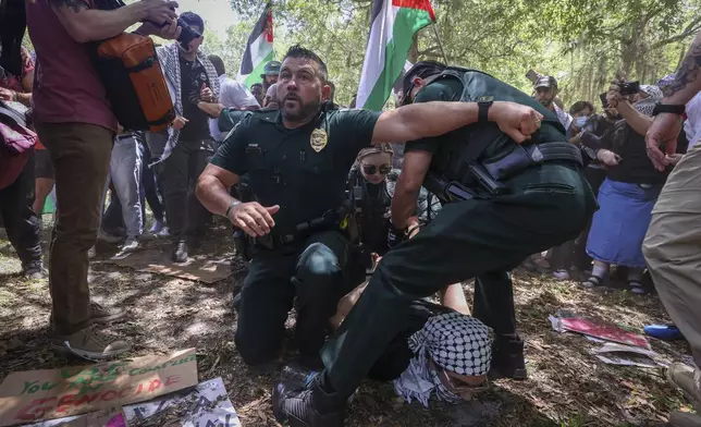 University of South Florida police officers take pro-Palestinian protesters into custody during a march on the campus Monday, April 29, 2024, in Tampa, Fla. (Chris Urso/Tampa Bay Times via AP)