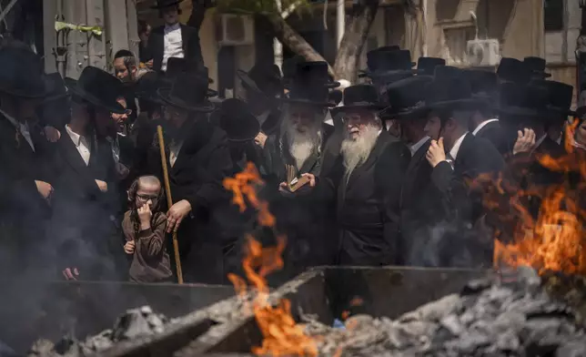 Ultra-Orthodox Jewish men and children burn leavened items in final preparation for the Passover holiday in the ultra-Orthodox Jewish town of Bnei Brak, near Tel Aviv, Israel, Monday, April 22, 2024. Jews are forbidden to eat leavened foodstuffs during the Passover holiday, which celebrates the biblical story of the Israelites' escape from slavery and exodus from Egypt. (AP Photo/Oded Balilty)