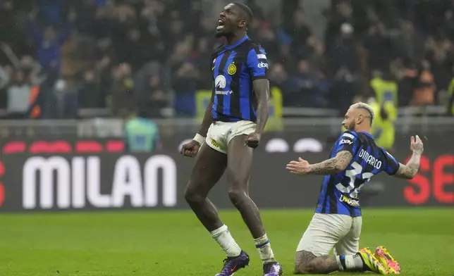 Inter Milan's Marcus Thuram, left, and Inter Milan's Federico Dimarco celebrate at the end of the Serie A soccer match between AC Milan and Inter Milan at the San Siro stadium in Milan, Italy, Monday, April 22, 2024. (AP Photo/Luca Bruno)