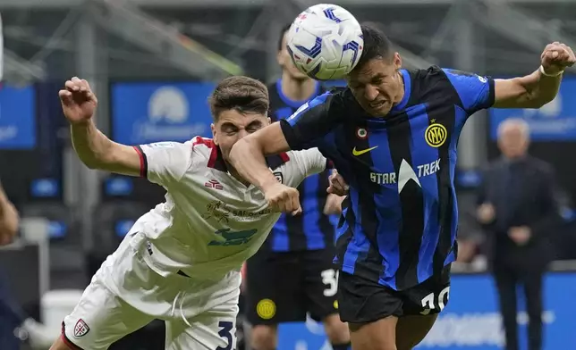 Inter Milan's Alexis Sanchez, right, heads the ball during the Italian Serie A soccer match between Inter Milan and Cagliari at the San Siro stadium in Milan, Italy, Sunday, April 14, 2024. (AP Photo/Antonio Calanni)