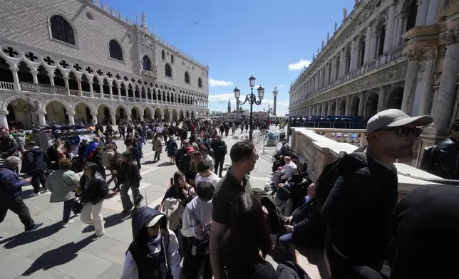 Tourists line up to enter at the at St.Mark bell tower in Venice, Italy, Thursday, April 25, 2024. The fragile lagoon city of Venice begins a pilot program Thursday to charge daytrippers a 5 euro entry fee that authorities hope will discourage tourists from arriving on peak days. (AP Photo/Luca Bruno)