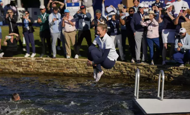 Nelly Korda jumps into the lake after winning the Chevron Championship LPGA golf tournament Sunday, April 21, 2024, at The Club at Carlton Woods in The Woodlands, Texas. (AP Photo/David J. Phillip)