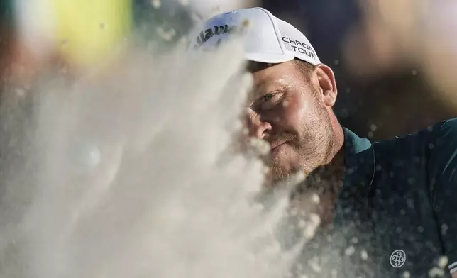 Danny Willett, of England, hits from the bunker on the 18th hole during third round at the Masters golf tournament at Augusta National Golf Club Saturday, April 13, 2024, in Augusta, Ga. (AP Photo/Charlie Riedel)