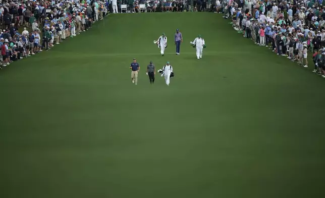 Sepp Straka, of Austria, Phil Mickelson and Tony Finau walk on the first hole during the first round at the Masters golf tournament at Augusta National Golf Club Thursday, April 11, 2024, in Augusta, Ga. (AP Photo/Matt Slocum)