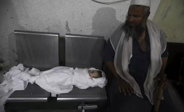 A Palestinian man sits while mourning his relative killed in the Israeli bombardment of the Gaza Strip at the morgue of the Kuwaiti Hospital in Rafah refugee camp, southern Gaza Strip, early Saturday, April 20, 2024. (AP Photo/Ismael Abu Dayyah)
