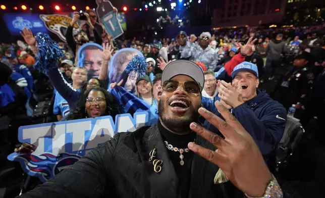 Alabama offensive lineman JC Latham celebrates with fans after being chosen by the Tennessee Titans with the seventh overall pick during the first round of the NFL football draft, Thursday, April 25, 2024, in Detroit. (AP Photo/Paul Sancya)