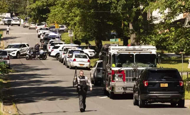 Multiple law enforcement vehicles respond in the neighborhood where several officers on a task force trying to serve a warrant were shot in Charlotte, N.C., Monday, April 29, 2024. (Melissa Melvin-Rodriguez/The Charlotte Observer via AP)