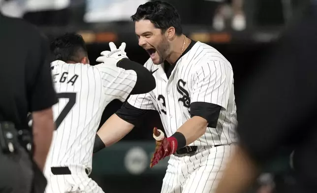 Chicago White Sox's Andrew Benintendi, right, begins to celebrate after his winning two-run home run off Tampa Bay Rays relief pitcher Phil Maton to end a 10-inning baseball game Saturday, April 27, 2024, in Chicago. (AP Photo/Charles Rex Arbogast)