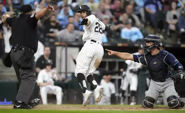 Tampa Bay Rays catcher Ben Rortvedt, right, looks to home plate umpire Marvin Hudson, left, as Hudson calls Chicago White Sox's Tommy Pham (28) safe at home after Pham scored on a single by Andrew Vaughn during the fifth inning of a baseball game Saturday, April 27, 2024, in Chicago. (AP Photo/Charles Rex Arbogast)