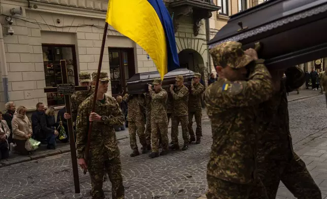 Soldiers carry the coffins of two Ukrainian army sergeants Tomkevych Mykhailo and Kril Olexander during their funeral at the Saints Peter and Paul church in Lviv, Ukraine, Tuesday, April 16, 2024. (AP Photo/Francisco Seco)
