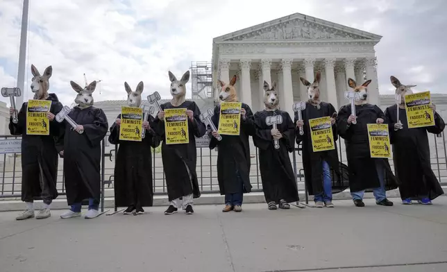 Demonstrators stand outside the Supreme Court as the justices prepare to hear arguments over whether Donald Trump is immune from prosecution in a case charging him with plotting to overturn the results of the 2020 presidential election, on Capitol Hill Thursday, April 25, 2024, in Washington. (AP Photo/Mariam Zuhaib)