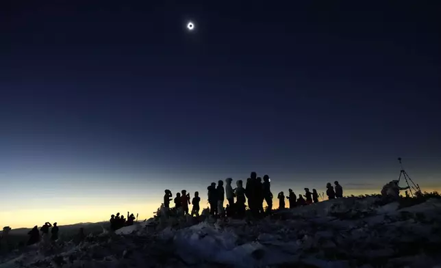 Skiers and hikers take in the view from the Appalachian Trail at the summit of Saddleback Mountain during the total solar eclipse, Monday, April 8, 2024, near Rangeley, Maine. (AP Photo/Robert F. Bukaty)