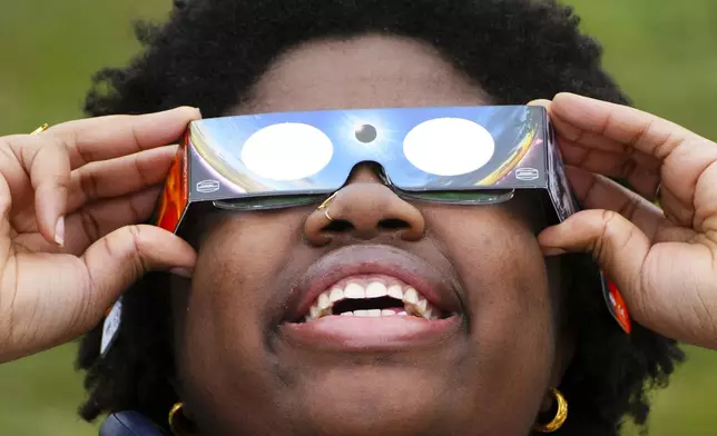 Siara Timothy-Mondesir watches the solar eclipse from Prince Edward County, Ontario, Monday, April 8, 2024. (Sean Kilpatrick/The Canadian Press via AP)
