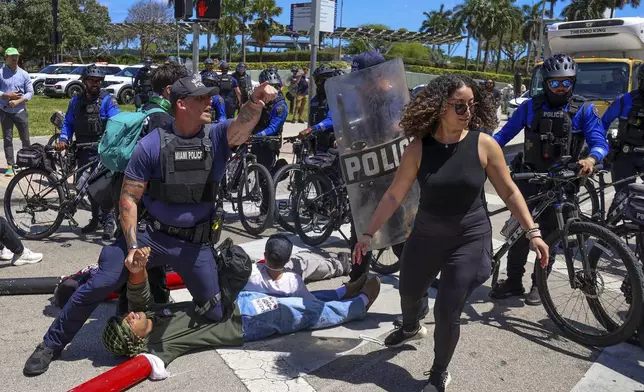 Protesters for a cease-fire in support of Gaza lie down in the intersection of NE 3rd Street and northbound Biscayne Boulevard and were later arrested by Miami Police, Monday, April 15, 2024, in downtown Miami. (Carl Juste/Miami Herald via AP)