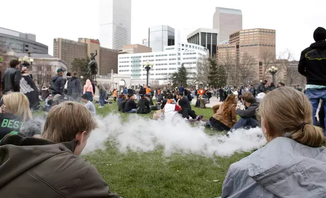 FILE - People smoke marijuana during the annual 4/20 marijuana gathering at Civic Center Park in downtown Denver, Wednesday, April 20, 2016. Marijuana advocates are gearing up for Saturday, April 20, 2024. Known as 4/20, marijuana's high holiday is marked by large crowds gathering in parks, at festivals and on college campuses to smoke together. This year, activists can reflect on how far the movement has come. (AP Photo/Brennan Linsley, File)