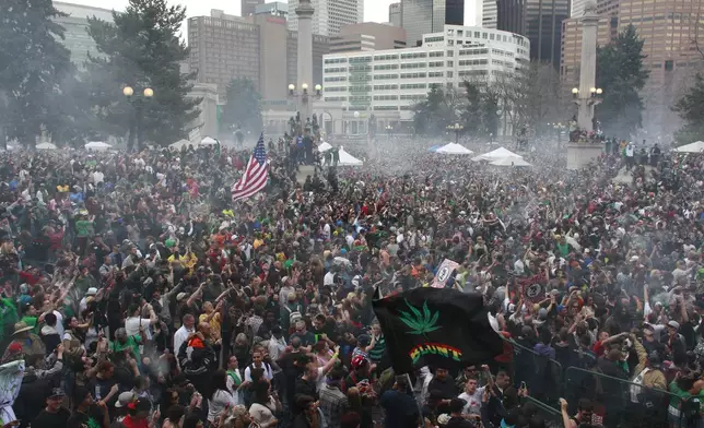 FILE - Members of a crowd numbering tens of thousands smoke marijuana and listen to live music at the Denver 420 pro-marijuana rally at Civic Center Park in Denver, April 20, 2013. Marijuana advocates are gearing up for Saturday, April 20, 2024. Known as 4/20, marijuana's high holiday is marked by large crowds gathering in parks, at festivals and on college campuses to smoke together. This year, activists can reflect on how far the movement has come. (AP Photo/Brennan Linsley, File)
