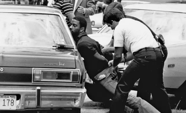 FILE - Police handcuff a suspect during a drug raid in Miami, May 18, 1979. Police said eight were arrested and marijuana was seized. Marijuana advocates are gearing up for Saturday, April 20, 2024. Known as 4/20, marijuana's high holiday is marked by large crowds gathering in parks, at festivals and on college campuses to smoke together. This year, activists can reflect on how far the movement has come. Medical marijuana is now legal in 38 states. (AP Photo/Al Diaz, File)