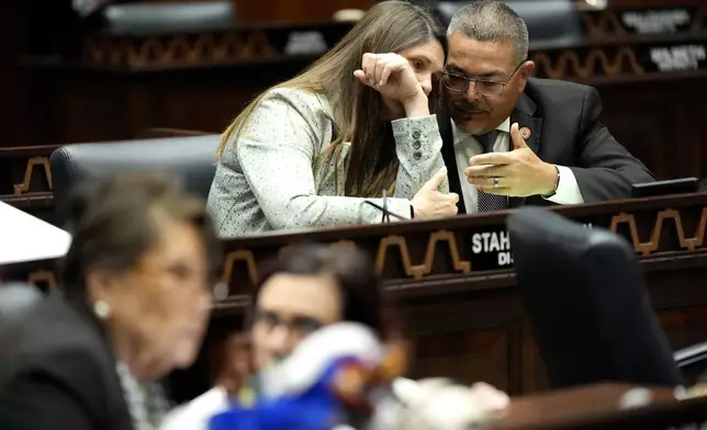 Arizona State Rep. Lupe Contreras, D, right, speaks with Stephanie Stahl Hamilton, D, on the House floor, Wednesday, April 17, 2024, at the Capitol in Phoenix. House Republicans have again blocked an effort for the chamber to take up legislation that would repeal Arizona’s near-total ban on abortions. (AP Photo/Matt York)
