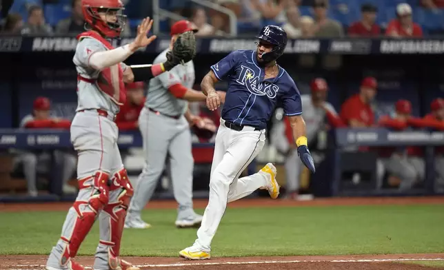 Tampa Bay Rays' Amed Rosario, right, scores next to Los Angeles Angels catcher Logan O'Hoppe on a two-run triple by Jose Caballero during the ninth inning of a baseball game Tuesday, April 16, 2024, in St. Petersburg, Fla. (AP Photo/Chris O'Meara)