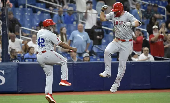 Los Angeles Angels' Mike Trout, right, celebrates with third base coach Eric Young Sr. after hitting a two-run home run off Tampa Bay Rays reliever Phil Maton during the eighth inning of a baseball game Monday, April 15, 2024, in St. Petersburg, Fla. (AP Photo/Steve Nesius)