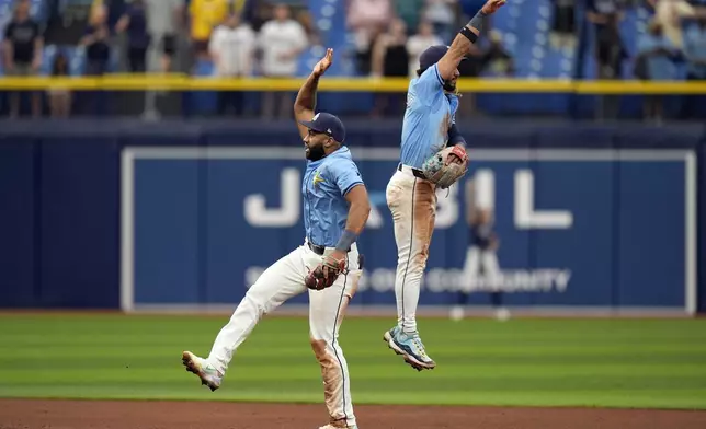 Tampa Bay Rays second baseman Amed Rosario, left, and shortstop Jose Caballero celebrate after the team defeated the Los Angeles Angels 2-1 in a baseball game Thursday, April 18, 2024, in St. Petersburg, Fla. (AP Photo/Chris O'Meara)