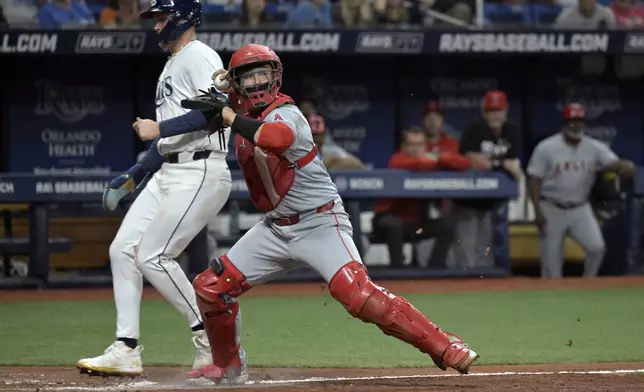 Los Angeles Angels catcher Matt Thaiss, right, forces out Tampa Bay Rays' Curtis Mead at the plate on a bases-loaded ground ball hit by Tampa Bay's Yandy Diaz during the fifth inning of a baseball game Monday, April 15, 2024, in St. Petersburg, Fla. (AP Photo/Steve Nesius)